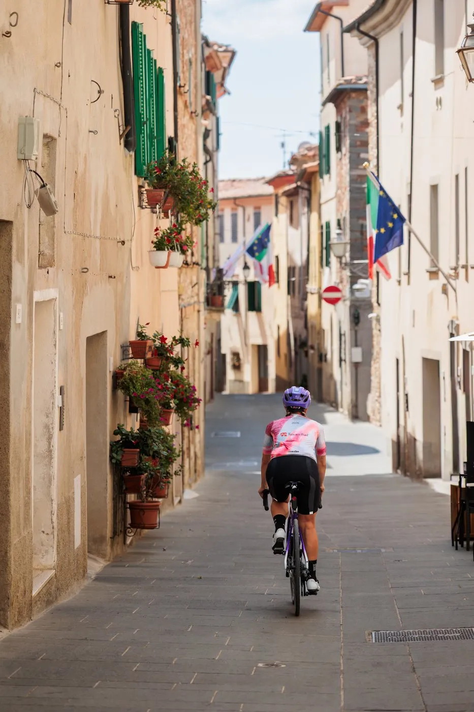 A cyclist riding through the narrow stone streets of Monterotondo Marittimo