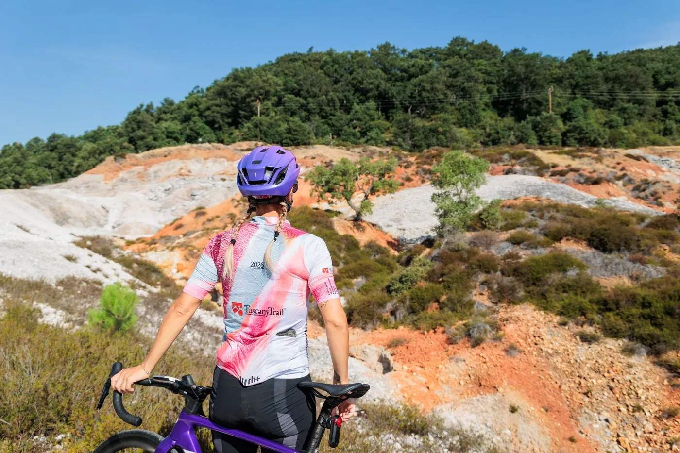 A cyclist looking over the white and ochre slopes of the Biancane geothermal park